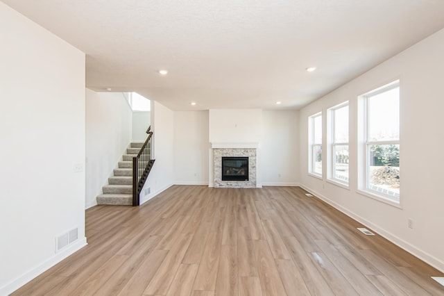 12114 Ivy St, Rogers, MN 55369 - unfurnished living room with light wood finished floors, stairway, recessed lighting, and a glass covered fireplace