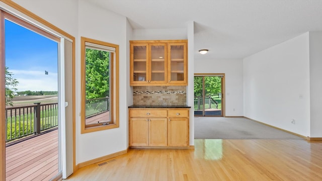 27285 Cambodia Ave, Castle Rock Twp, MN 55024 - kitchen featuring light wood-style floors, backsplash, baseboards, and glass insert cabinets