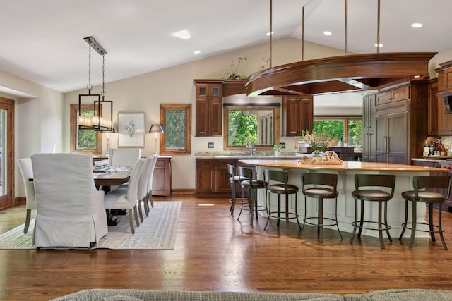 1405 Farm Rd, Chanhassen, MN 55318 - kitchen with lofted ceiling, a kitchen island, light countertops, a breakfast bar, and glass insert cabinets
