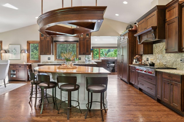 1405 Farm Rd, Chanhassen, MN 55318 - kitchen with lofted ceiling, stainless steel gas cooktop, a center island, decorative backsplash, and a breakfast bar