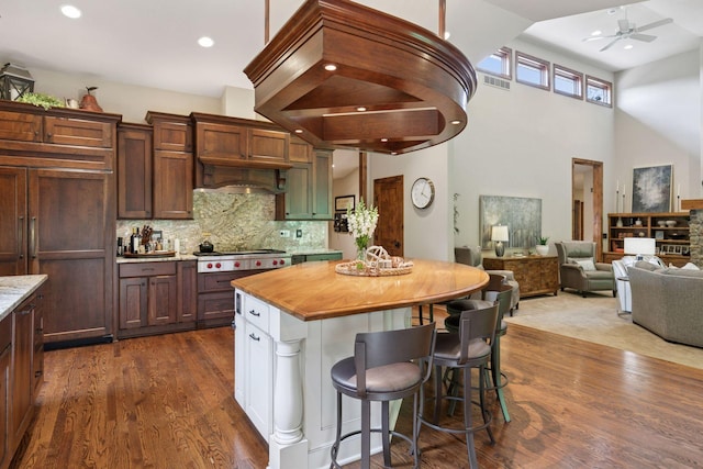1405 Farm Rd, Chanhassen, MN 55318 - kitchen featuring stainless steel gas cooktop, a kitchen bar, dark wood-style flooring, a ceiling fan, and decorative backsplash