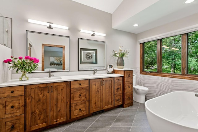 1405 Farm Rd, Chanhassen, MN 55318 - bathroom with a soaking tub, double vanity, tile patterned floors, toilet, and tile walls