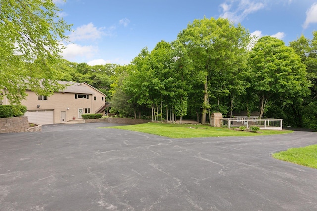 1405 Farm Rd, Chanhassen, MN 55318 - view of grassy yard featuring driveway, view of wooded area, and a garage