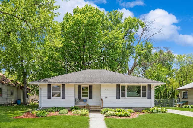 613 9th St NW, Faribault, MN 55021 - view of front of house featuring a front yard, covered porch, and roof with shingles