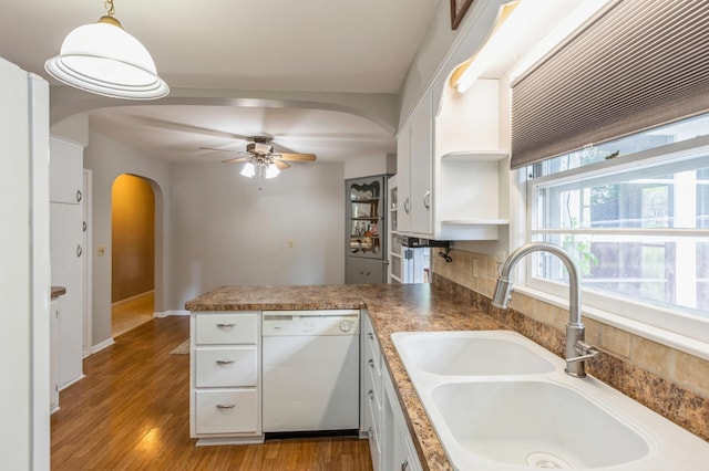 613 9th St NW, Faribault, MN 55021 - kitchen with dishwasher, arched walkways, a sink, a peninsula, and white cabinets