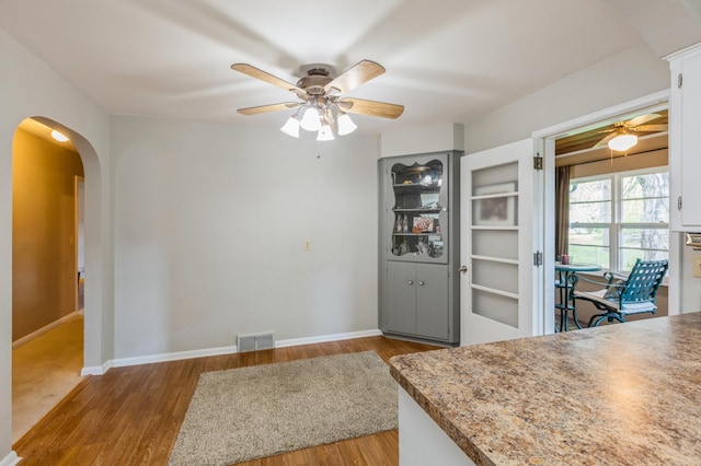 613 9th St NW, Faribault, MN 55021 - dining room with ceiling fan, arched walkways, wood finished floors, and baseboards
