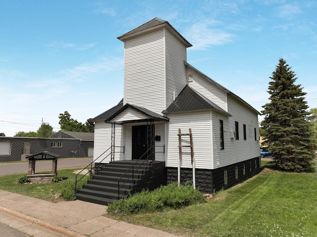 324 Douglas St, Chetek, WI 54728 - view of front facade featuring metal roof, a front yard, and a standing seam roof