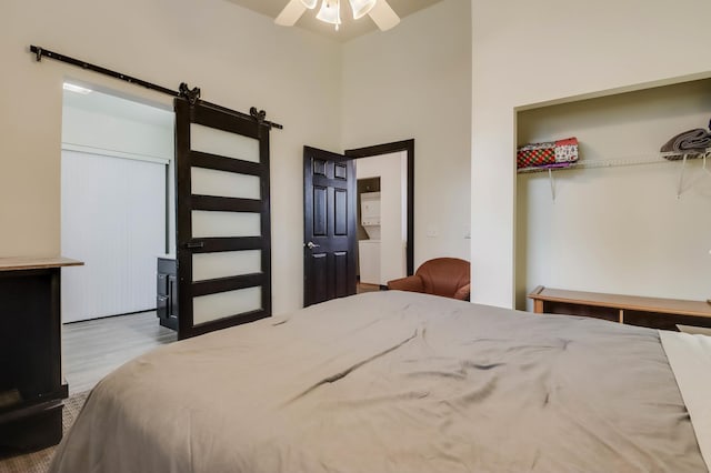 324 Douglas St, Chetek, WI 54728 - bedroom featuring a barn door, wood finished floors, and a ceiling fan