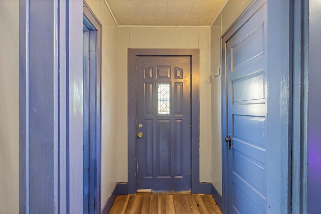 202 6th Ave, Bovey, MN 55709 - doorway to outside featuring wood finished floors, baseboards, and crown molding
