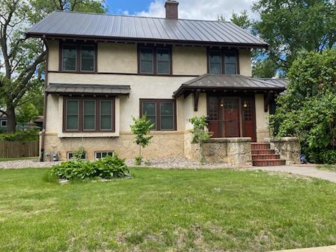 503 14th Ave SW, Rochester, MN 55902 - view of front facade with stucco siding, metal roof, a chimney, and a standing seam roof