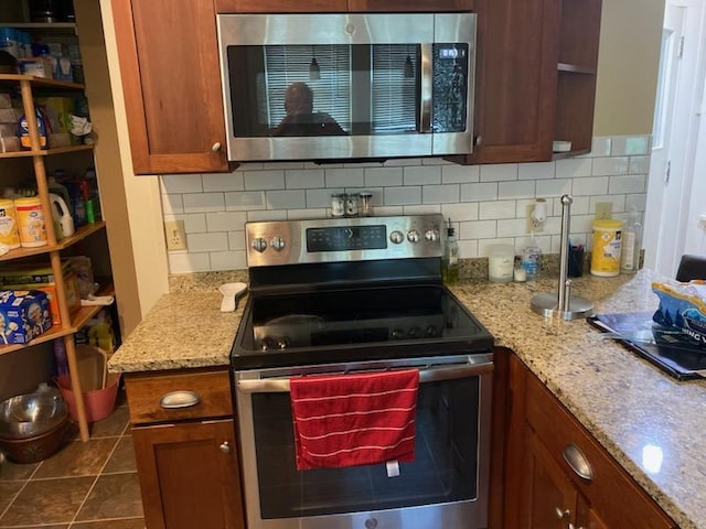 503 14th Ave SW, Rochester, MN 55902 - kitchen featuring stainless steel appliances, backsplash, brown cabinetry, and light stone counters