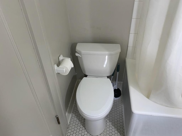 503 14th Ave SW, Rochester, MN 55902 - bathroom with toilet, curtained shower, tile patterned floors, and a bath