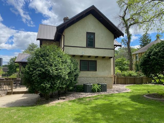 503 14th Ave SW, Rochester, MN 55902 - rear view of house with metal roof, a chimney, a deck, and stucco siding