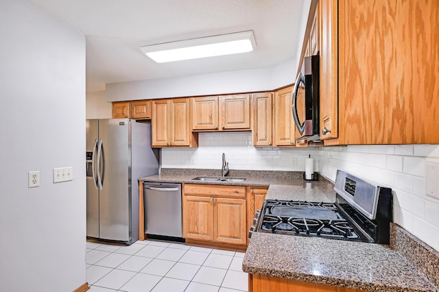 5030 Sheridan Ave S, Minneapolis, MN 55410 - kitchen featuring appliances with stainless steel finishes, decorative backsplash, light tile patterned floors, and dark stone countertops