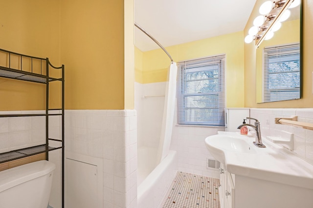 5030 Sheridan Ave S, Minneapolis, MN 55410 - full bathroom with tile walls, vanity, a wainscoted wall, tile patterned floors, and shower / tub combo
