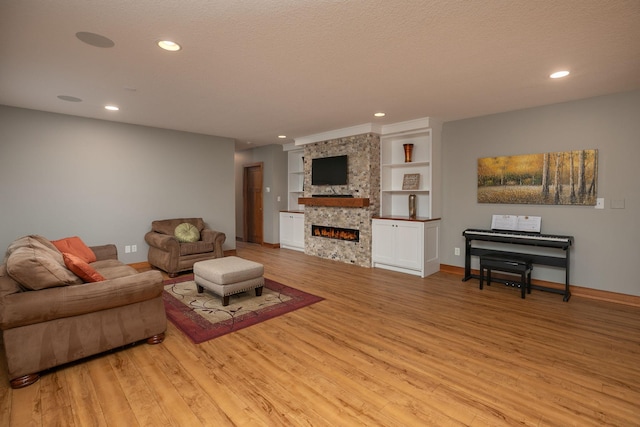1121 Maplebeck Enclave NE, Byron, MN 55920 - living area with light wood finished floors, a fireplace, recessed lighting, and baseboards
