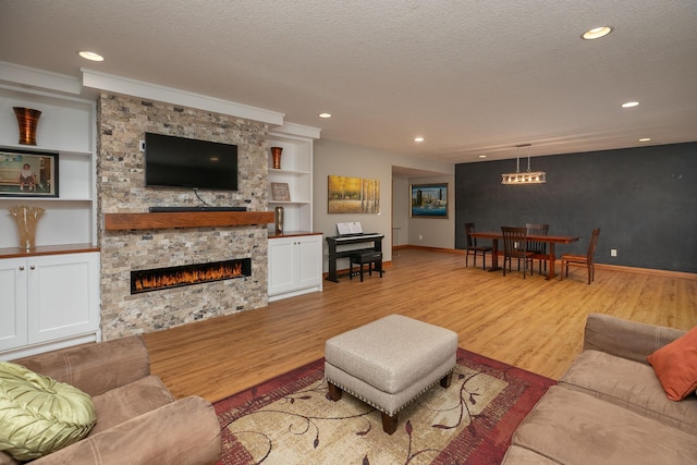 1121 Maplebeck Enclave NE, Byron, MN 55920 - living area featuring wood finished floors, baseboards, a stone fireplace, a textured ceiling, and built in features