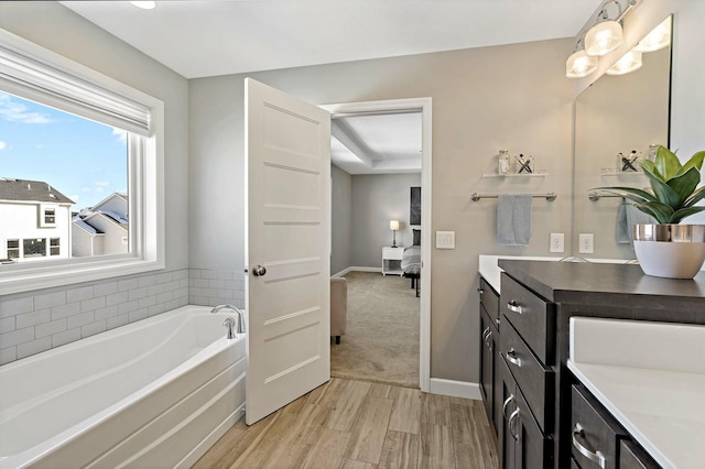 11686 32nd St N, Lake Elmo, MN 55042 - full bathroom featuring a bath, vanity, wood finished floors, and baseboards