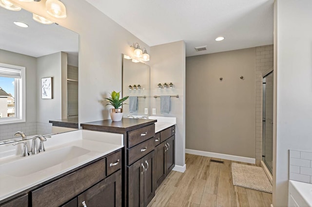 11686 32nd St N, Lake Elmo, MN 55042 - full bath with wood finished floors, vanity, tiled shower, recessed lighting, and baseboards
