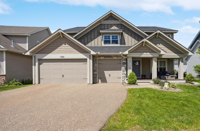 11686 32nd St N, Lake Elmo, MN 55042 - view of front of house with asphalt driveway, covered porch, a front yard, board and batten siding, and an attached garage