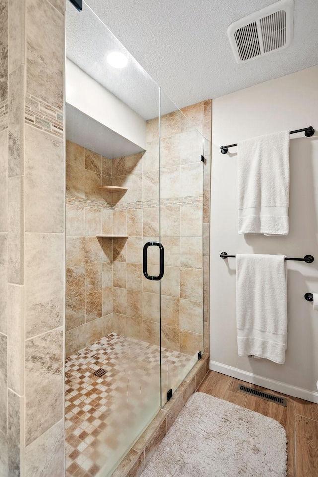 11422 71st Ave N, Maple Grove, MN 55369 - full bathroom with wood finished floors, a textured ceiling, a shower stall, baseboards, and recessed lighting