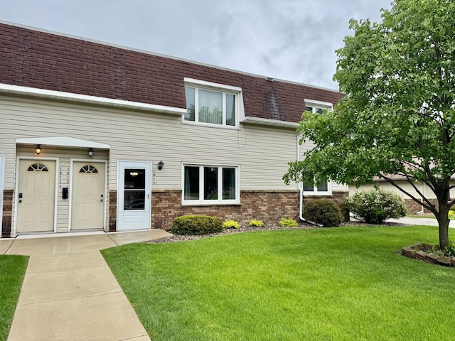 1815 Lakewood Ave, Albert Lea, MN 56007 - view of front of home featuring mansard roof, a shingled roof, a front lawn, and brick siding