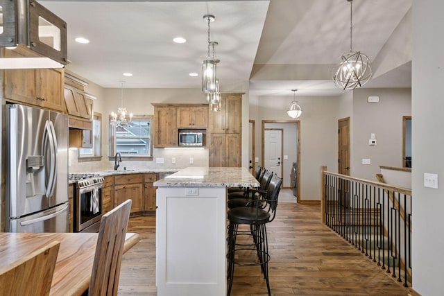 525 Roanoke Ct, Waconia, MN 55387 - kitchen featuring appliances with stainless steel finishes, a chandelier, a sink, wood finished floors, and recessed lighting