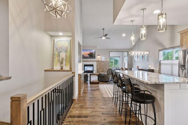 525 Roanoke Ct, Waconia, MN 55387 - kitchen featuring healthy amount of natural light, wood finished floors, high vaulted ceiling, a chandelier, and ceiling fan