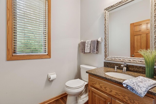 18172 Tamarack Dr, Minnetonka, MN 55345 - bathroom featuring vanity, toilet, wood finished floors, and baseboards