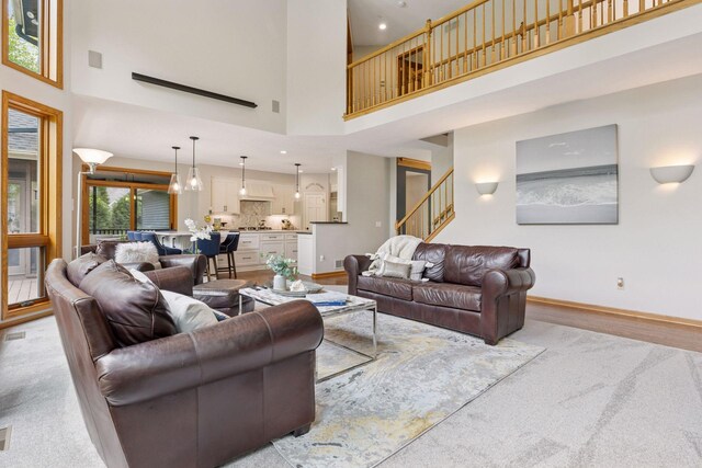 18172 Tamarack Dr, Minnetonka, MN 55345 - living area featuring a towering ceiling, baseboards, stairway, light wood-type flooring, and recessed lighting