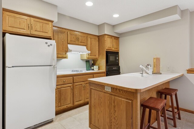 18172 Tamarack Dr, Minnetonka, MN 55345 - kitchen featuring black appliances, under cabinet range hood, a sink, a peninsula, and a breakfast bar area