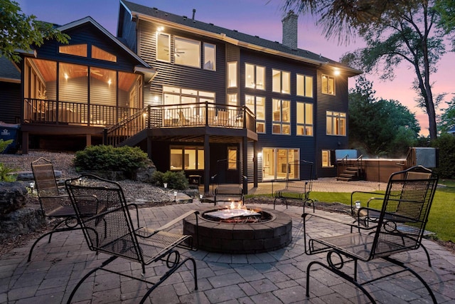 18172 Tamarack Dr, Minnetonka, MN 55345 - back of house at dusk featuring a fire pit, a chimney, a patio, and stairway