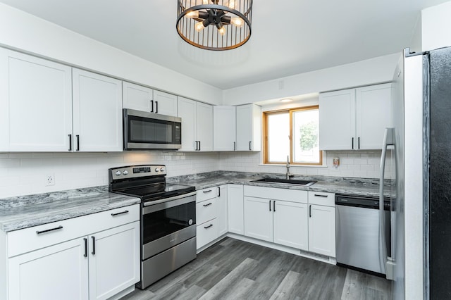 311 Wisconsin St, Lake City, MN 55041 - kitchen with appliances with stainless steel finishes, a sink, tasteful backsplash, and dark wood-type flooring