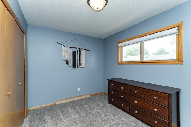 311 Wisconsin St, Lake City, MN 55041 - carpeted bedroom featuring a baseboard heating unit, baseboards, a closet, and a textured ceiling