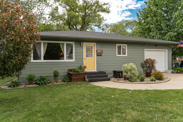 311 Wisconsin St, Lake City, MN 55041 - view of front facade featuring a front lawn, an attached garage, driveway, and a shingled roof