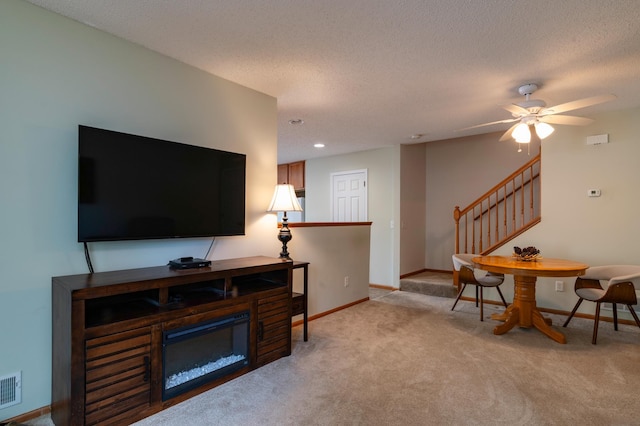 4960 149th St N Unit 6, Hugo, MN 55038 - living area featuring stairs, light carpet, baseboards, a ceiling fan, and a textured ceiling