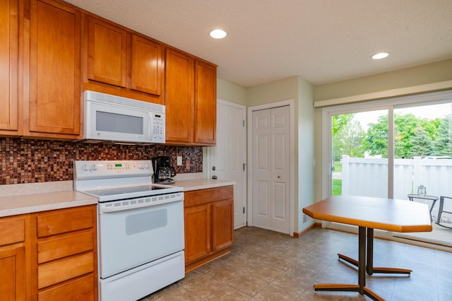 4960 149th St N Unit 6, Hugo, MN 55038 - kitchen featuring white appliances, decorative backsplash, light countertops, brown cabinets, and recessed lighting