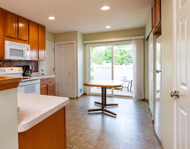 4960 149th St N Unit 6, Hugo, MN 55038 - kitchen featuring white appliances, brown cabinetry, light countertops, baseboards, and recessed lighting