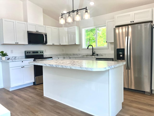 826 Sims Ave, Saint Paul, MN 55106 - kitchen featuring appliances with stainless steel finishes, a kitchen island, light countertops, a sink, and vaulted ceiling