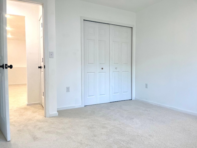 826 Sims Ave, Saint Paul, MN 55106 - unfurnished bedroom featuring light carpet, a closet, and baseboards