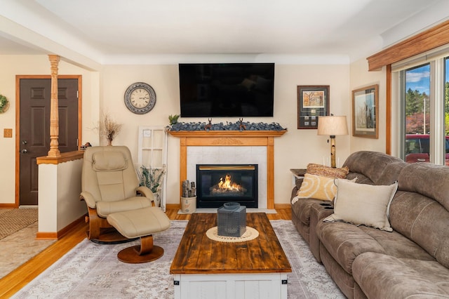 721 Maple Dr, Aurora, MN 55705 - living area with wood finished floors, a tiled fireplace, and baseboards