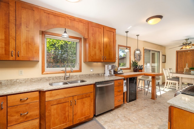 721 Maple Dr, Aurora, MN 55705 - kitchen featuring stainless steel dishwasher, a sink, brown cabinets, and pendant lighting