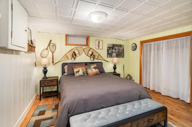 721 Maple Dr, Aurora, MN 55705 - bedroom featuring light wood-style floors, baseboards, an ornate ceiling, and wooden walls