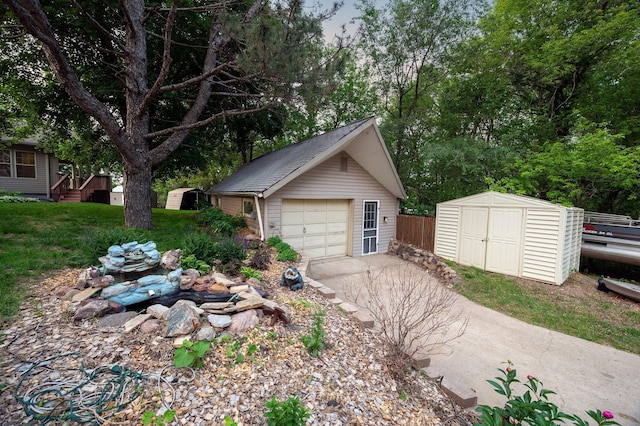 614 S Shore Dr S, Windom, MN 56101 - detached garage with a storage unit, driveway, and view of wooded area