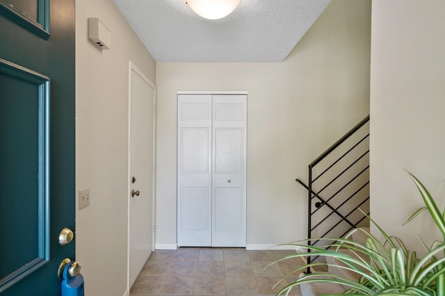 17915 17th Ave N, Plymouth, MN 55447 - foyer with a textured ceiling, tile patterned floors, stairs, and baseboards