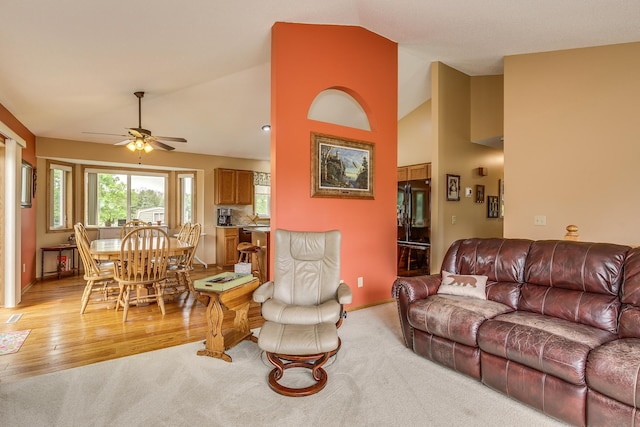28610 Bay Shore Dr NW, Isanti, MN 55040 - living room featuring a ceiling fan, light carpet, baseboards, light wood-style flooring, and high vaulted ceiling