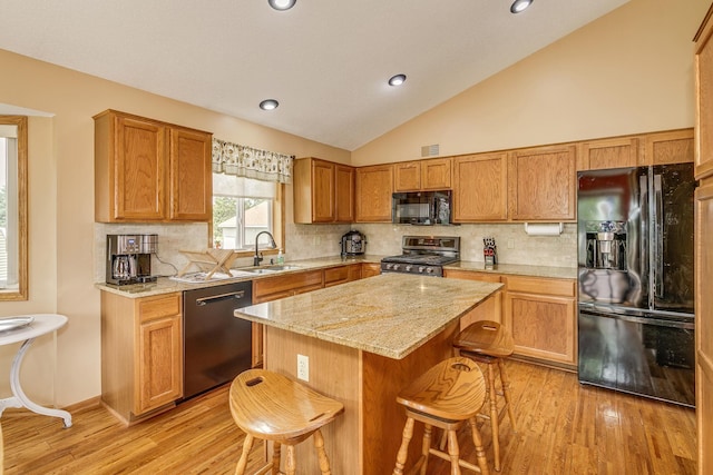28610 Bay Shore Dr NW, Isanti, MN 55040 - kitchen featuring black appliances, a sink, light wood-style flooring, a kitchen bar, and lofted ceiling
