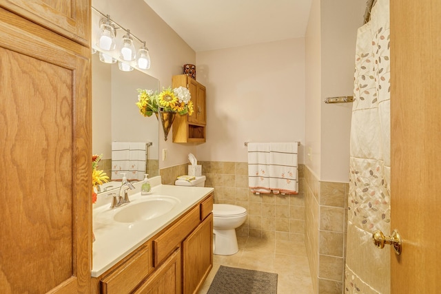 28610 Bay Shore Dr NW, Isanti, MN 55040 - bathroom featuring vanity, toilet, a wainscoted wall, tile walls, and tile patterned flooring