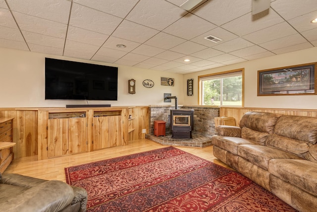 28610 Bay Shore Dr NW, Isanti, MN 55040 - living room featuring a wood stove, a wainscoted wall, light wood-type flooring, wood walls, and recessed lighting