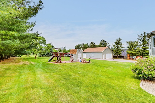 28610 Bay Shore Dr NW, Isanti, MN 55040 - view of green lawn featuring an outbuilding, a playground, concrete driveway, and a detached garage